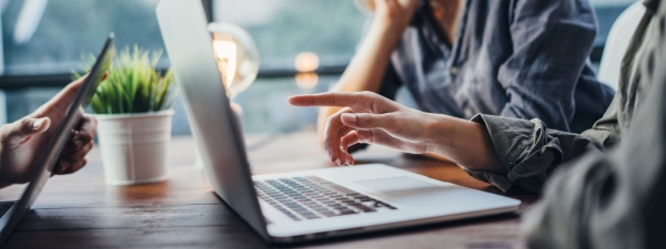 a person pointing at a laptop