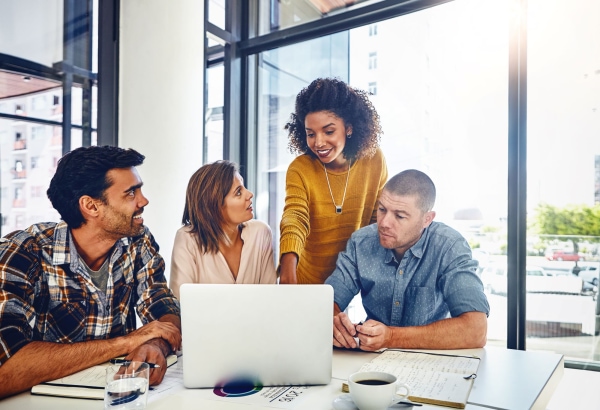 a group of people looking at a laptop